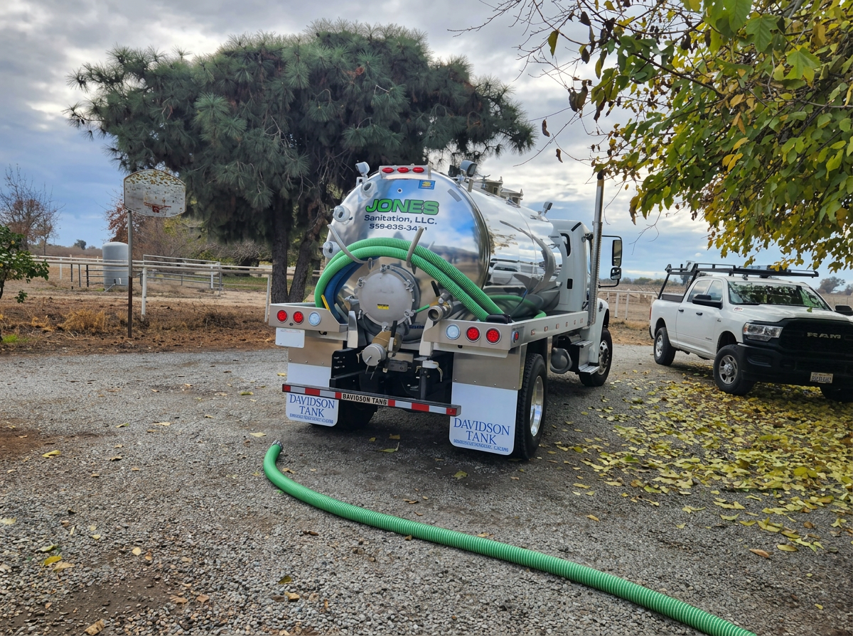 Jones Sanitation LLC chrome septic vacuum truck with green hose on a Central Valley service call